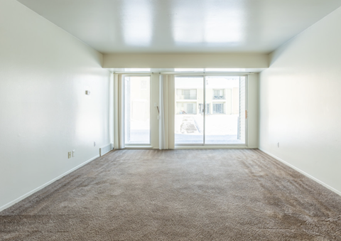 an empty living room with white walls and a carpet
