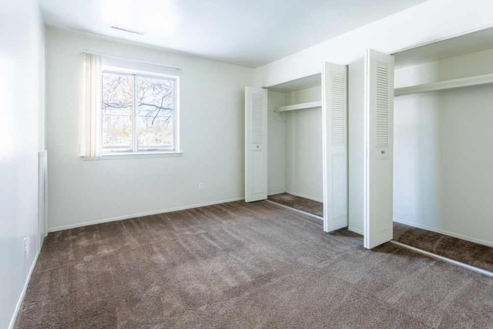 an empty room with two closets and a window