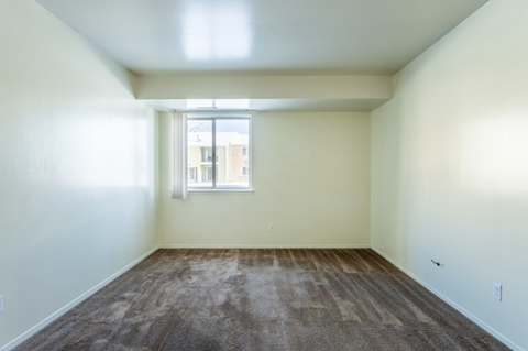 an empty room with carpet and a window