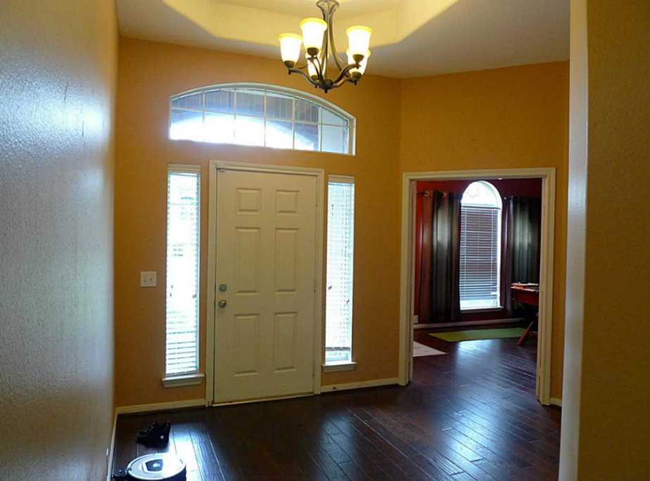 an empty living room with a white door and a window