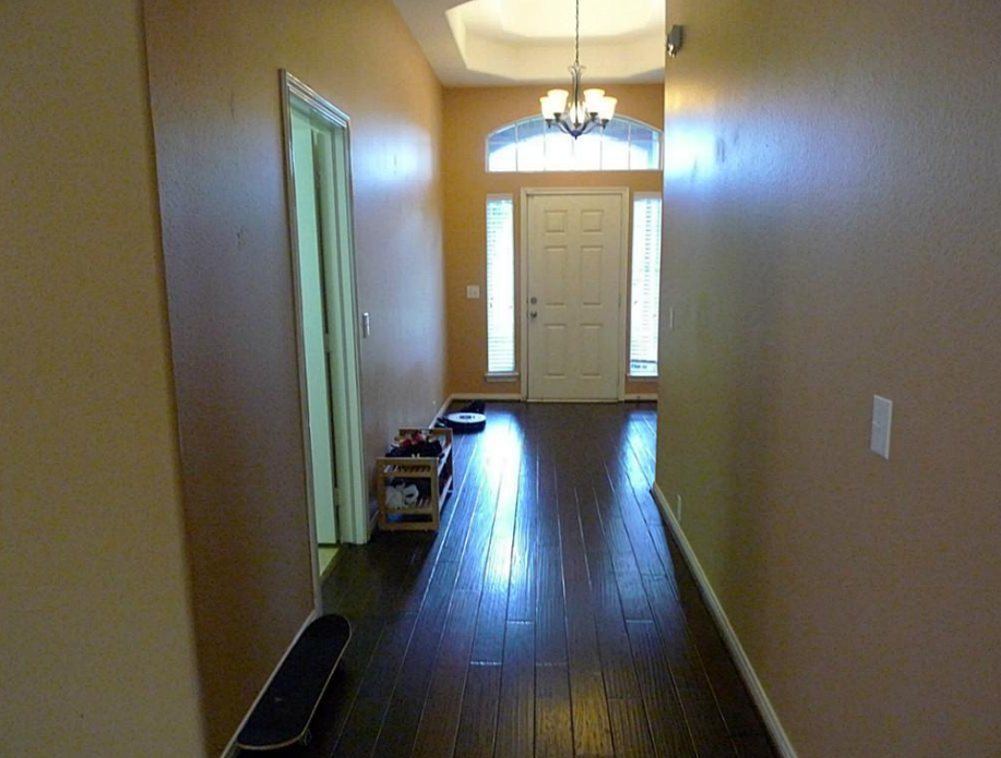 an empty living room with a wooden floor and a white door