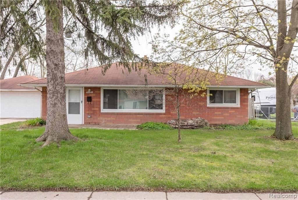 a small brick house with trees in front of it
