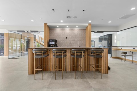 the kitchen has a large island with bar stools and a wall of windows