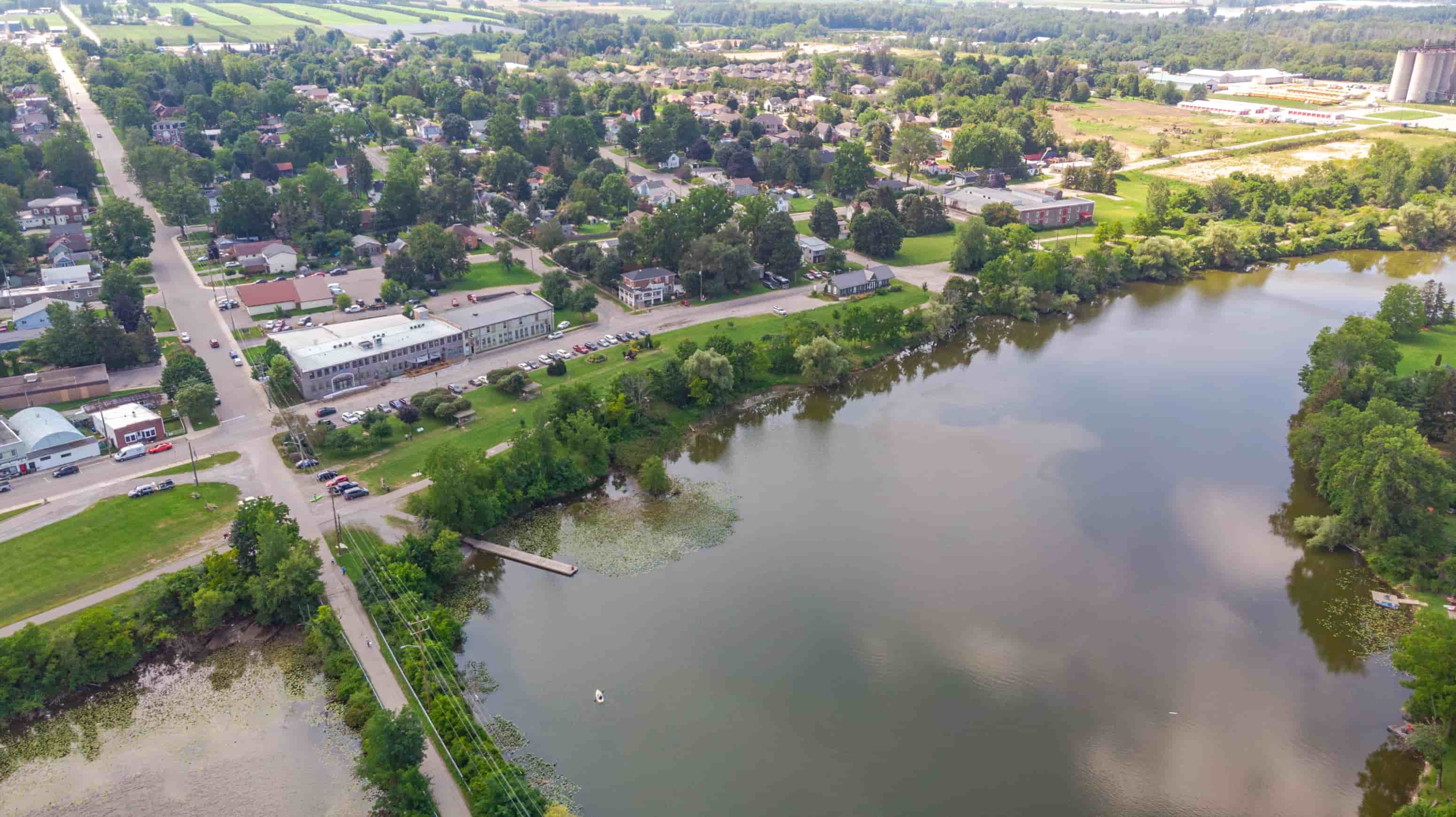A large body of water surrounded by greenery and buildings.