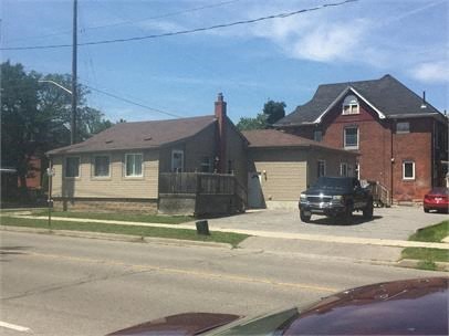 A black truck is parked in front of a red car.