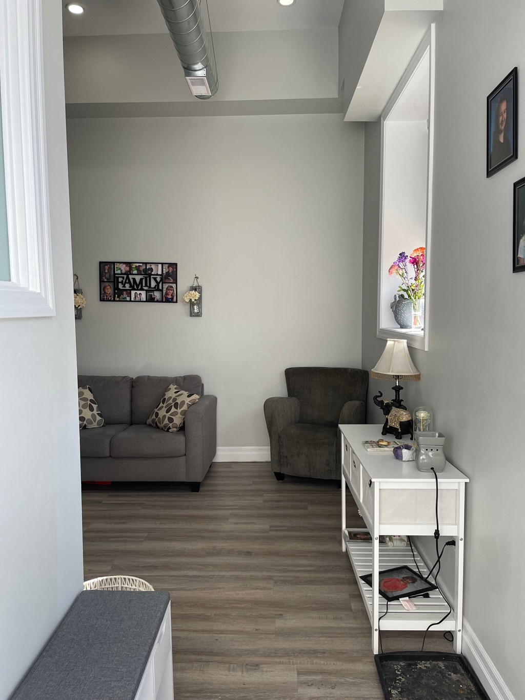 A room with a grey couch and a brown armchair.