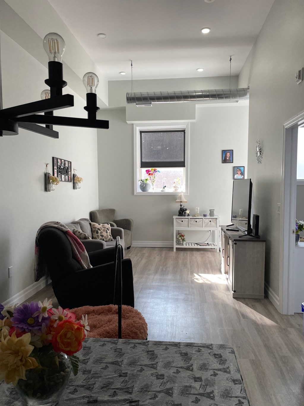 A living room with a couch, chair, and a table with flowers on it.