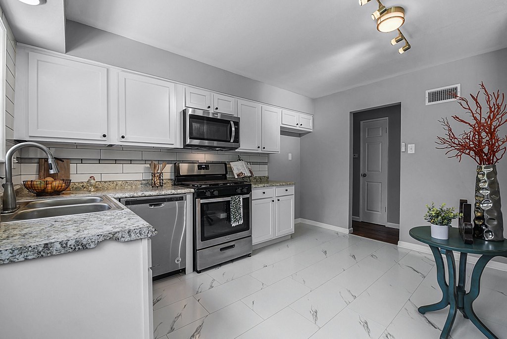 a kitchen with stainless steel appliances and white cabinets