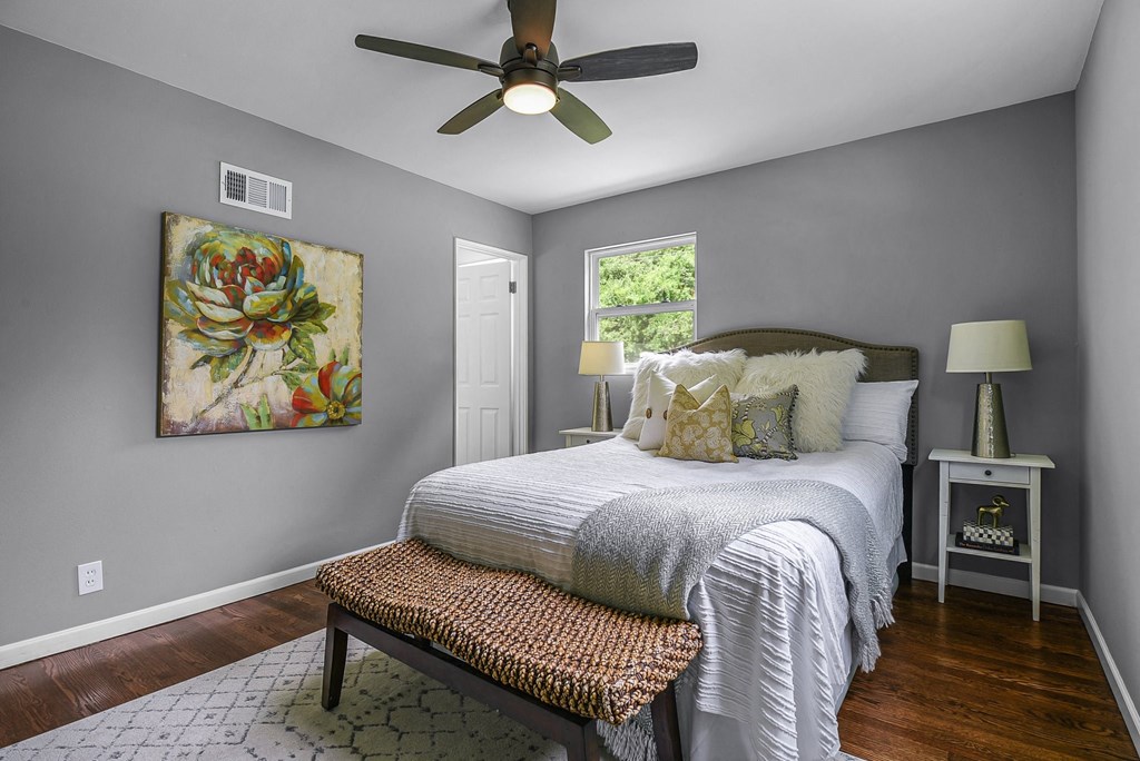 a bedroom with a bed and a ceiling fan