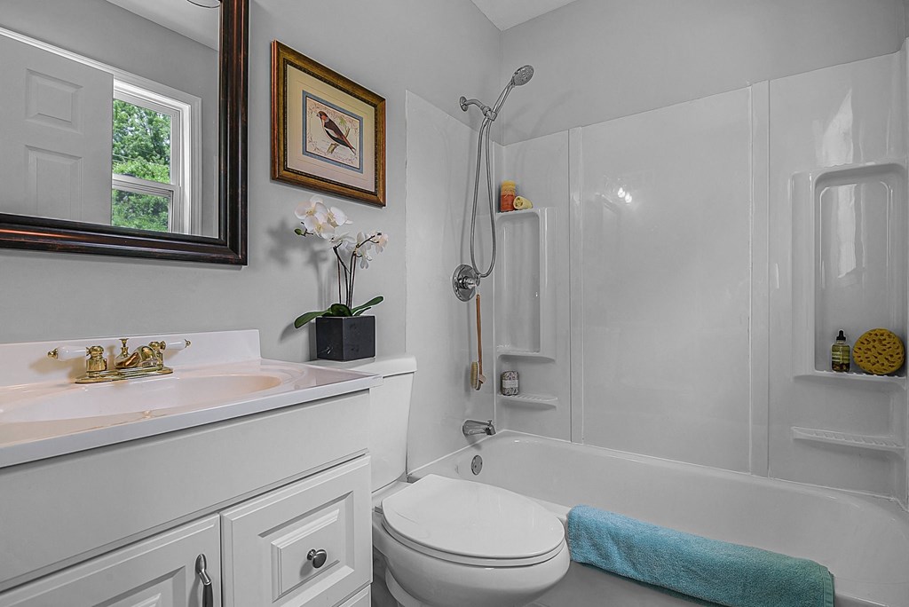 a white bathroom with a shower and a sink and a toilet
