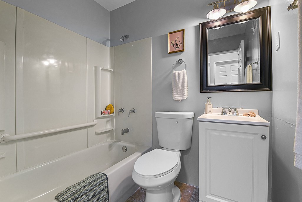 a bathroom with a toilet and a tub and a sink