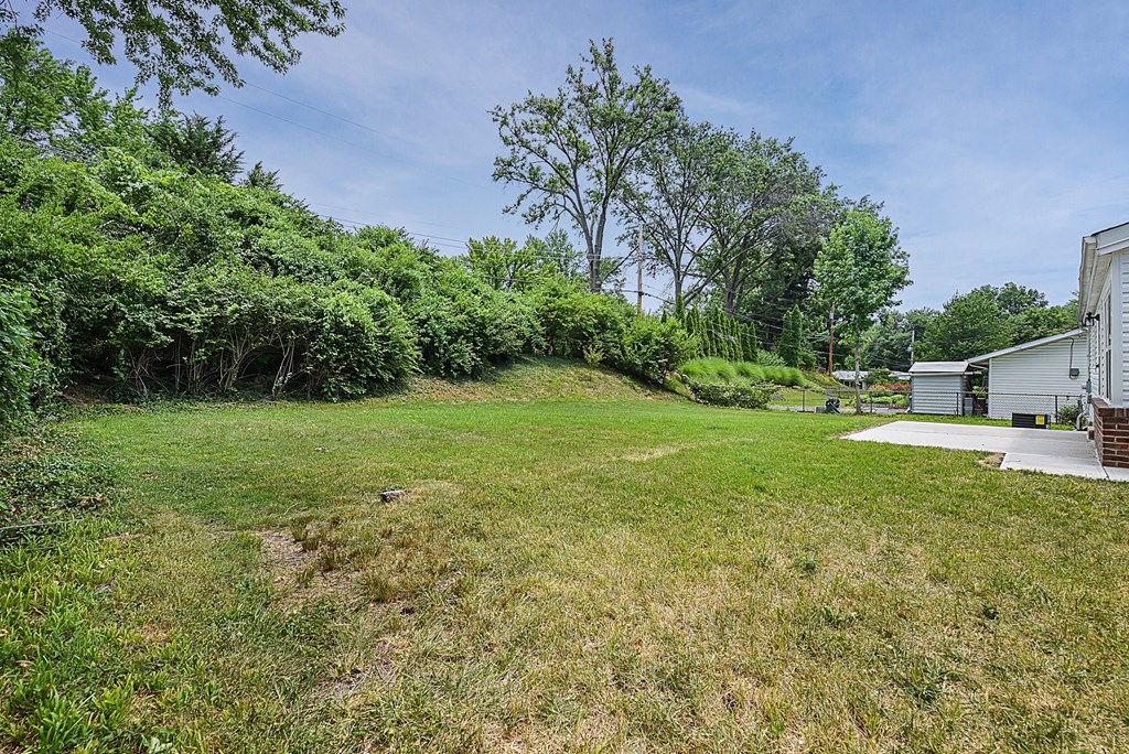 a backyard with a house and a yard with grass and trees