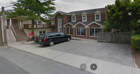 A black van is parked in front of a house.