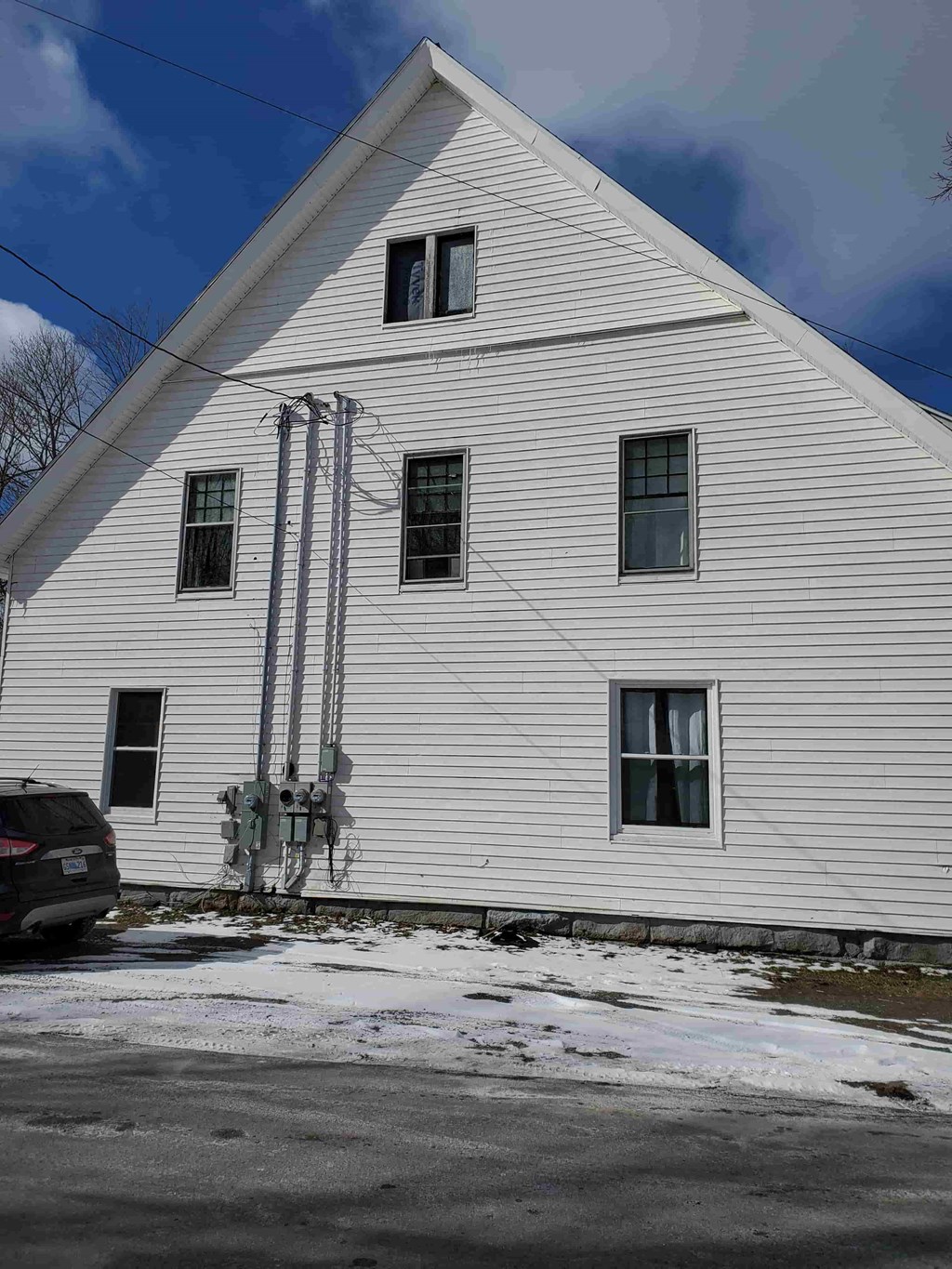 the outside of a white building with snow on the ground