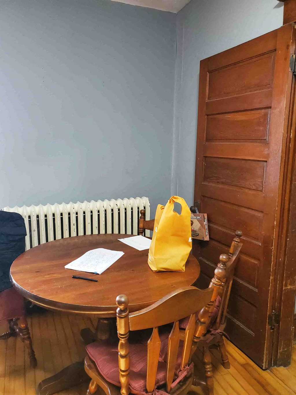 a table and chairs in a room with a door and a radiator