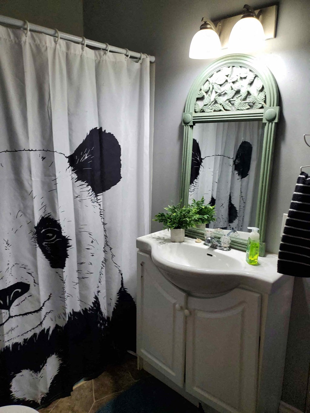 a bathroom with a black and white shower curtain and a sink