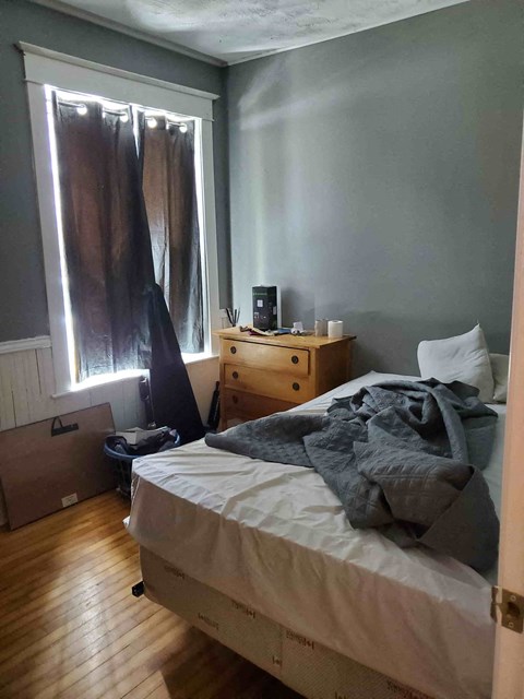 a bedroom with a bed and a dresser and a window