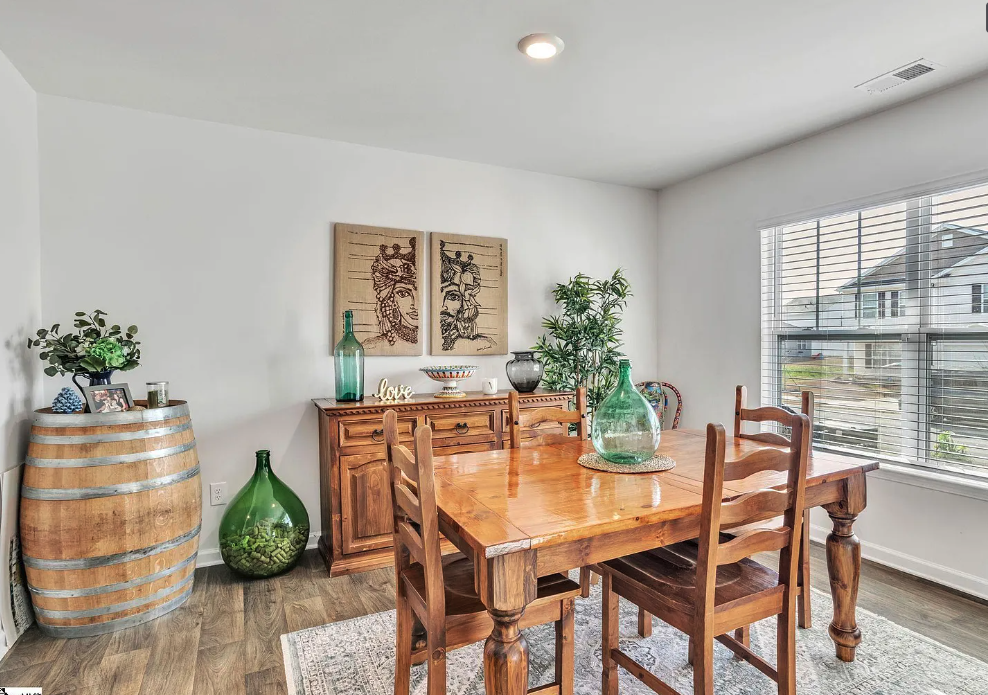 a dining room with a wooden table and chairs