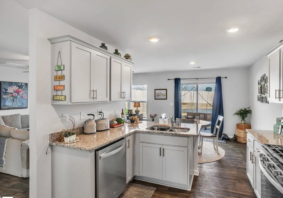 a kitchen with white cabinets and a counter top and a sink