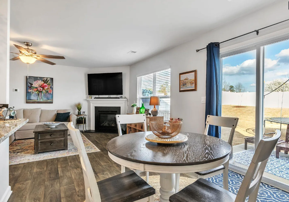 a living room with a round table and a fireplace