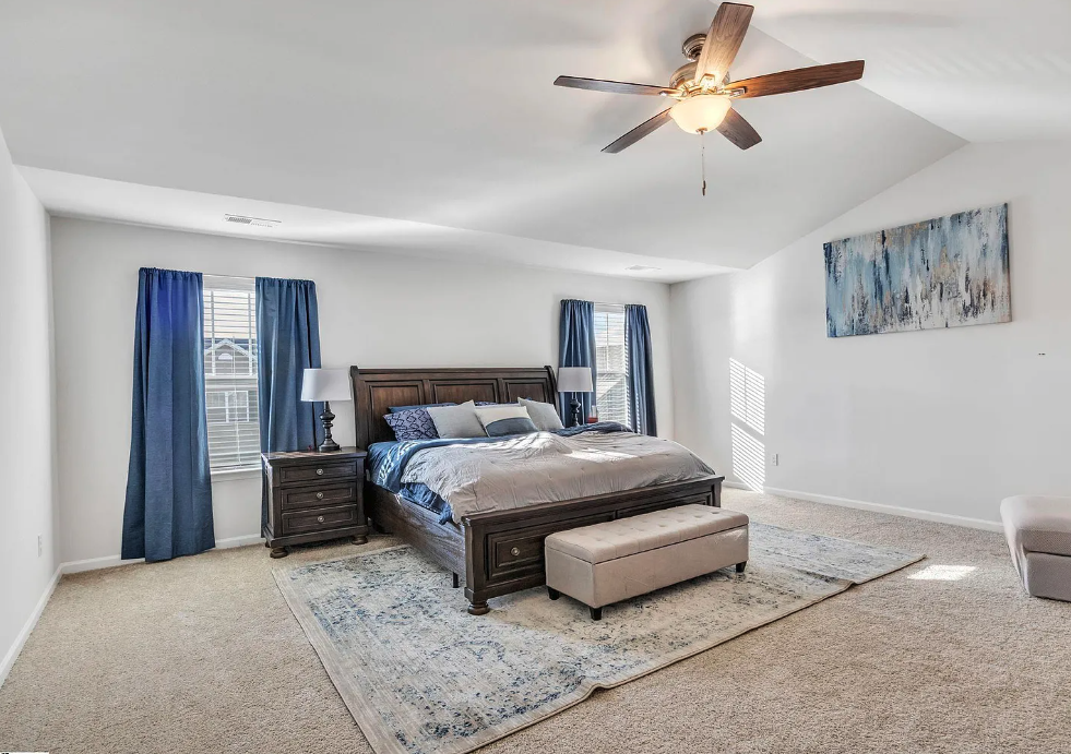 a bedroom with a bed and a ceiling fan