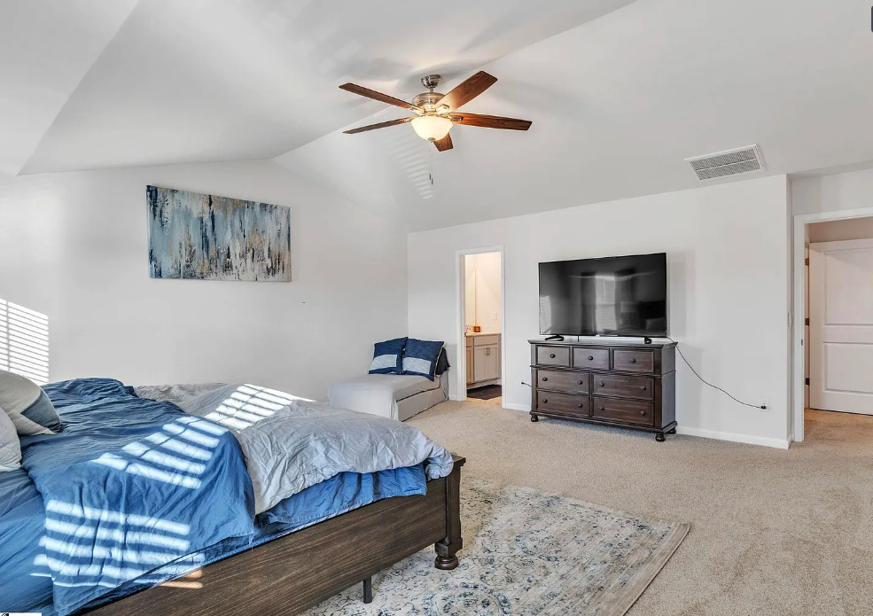 a bedroom with a bed and a ceiling fan
