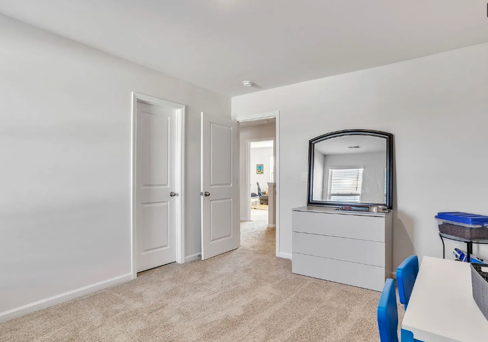 a living room with a mirror and a desk