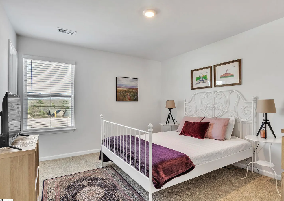 a bedroom with a white bed and a window