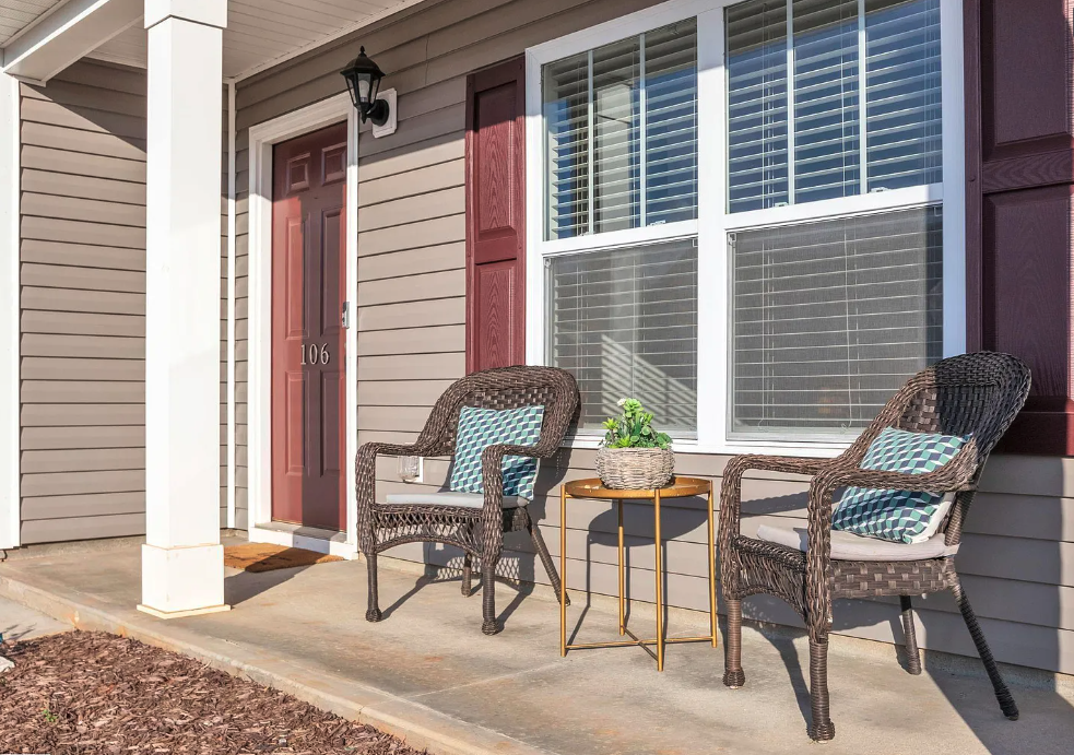 two chairs sitting on a porch in front of a house