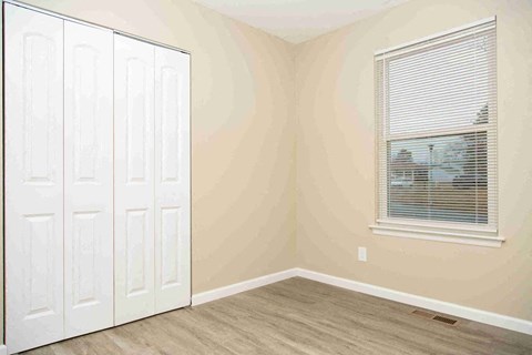 a bedroom with a closet and a window and a door