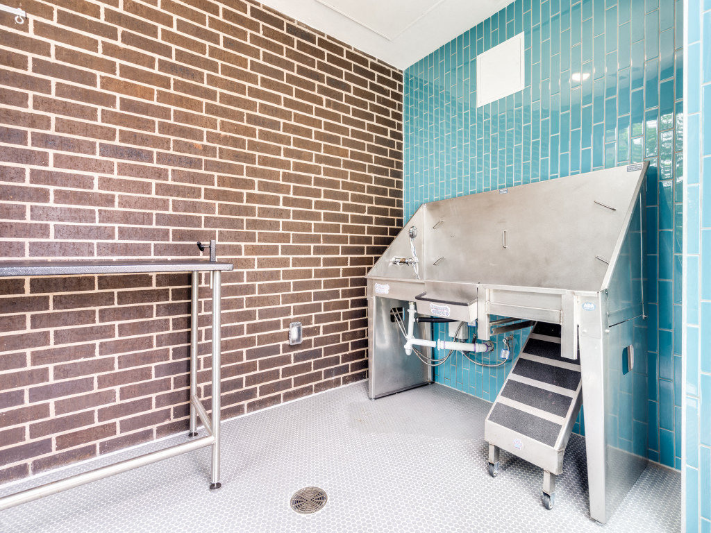 a kitchen with a stainless steel stove and a brick wall