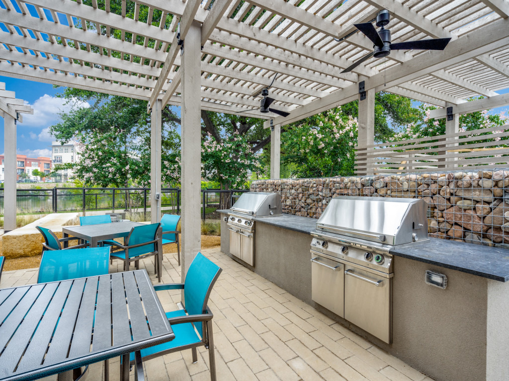 a patio with stainless steel appliances and a pergola