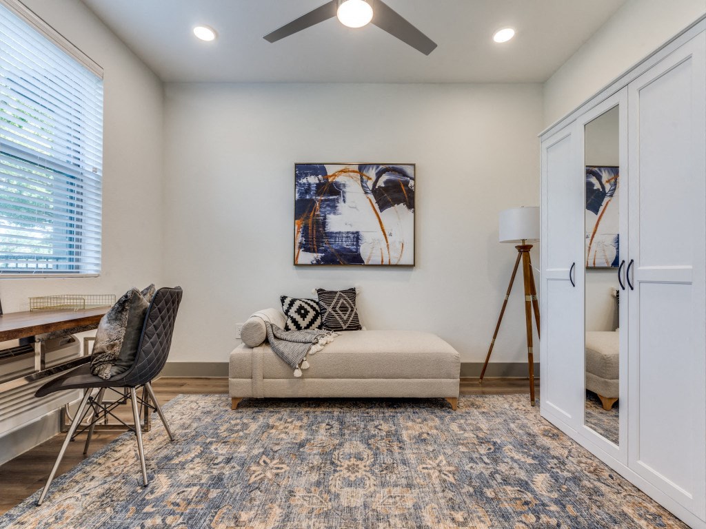 a living room with a couch and a desk and a mirror