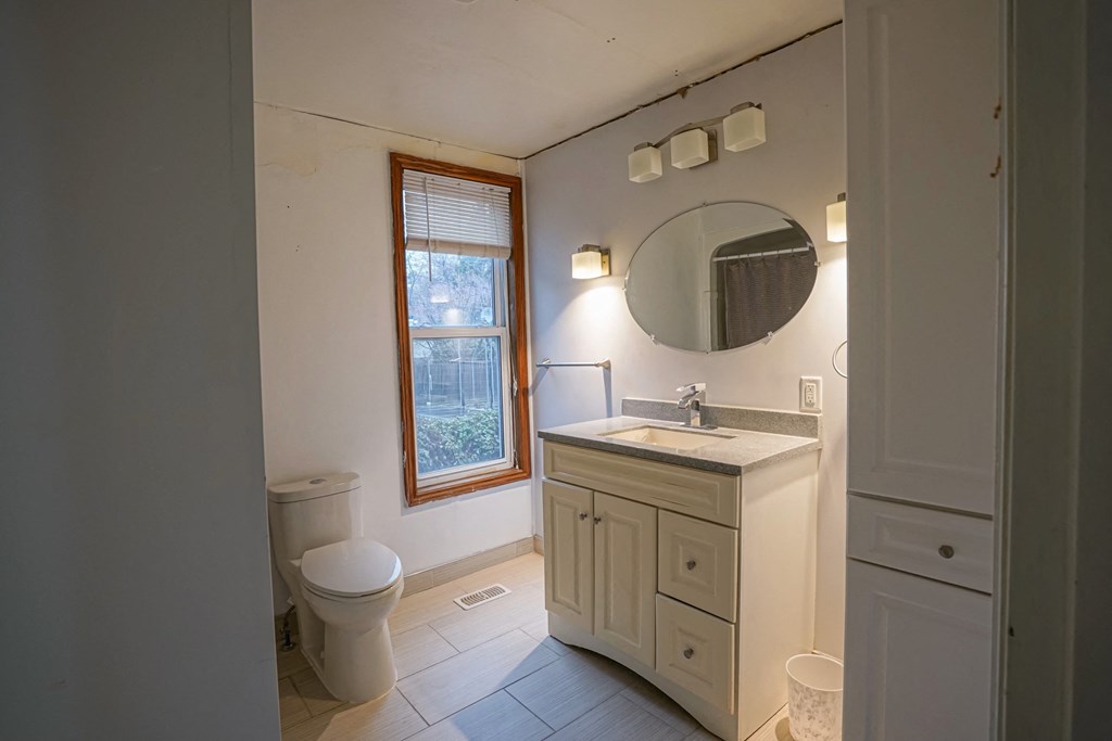 a bathroom with a toilet and a sink and a mirror