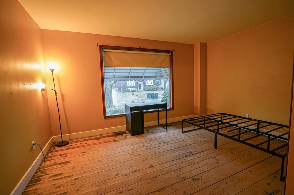 an empty room with a window and a bed in it