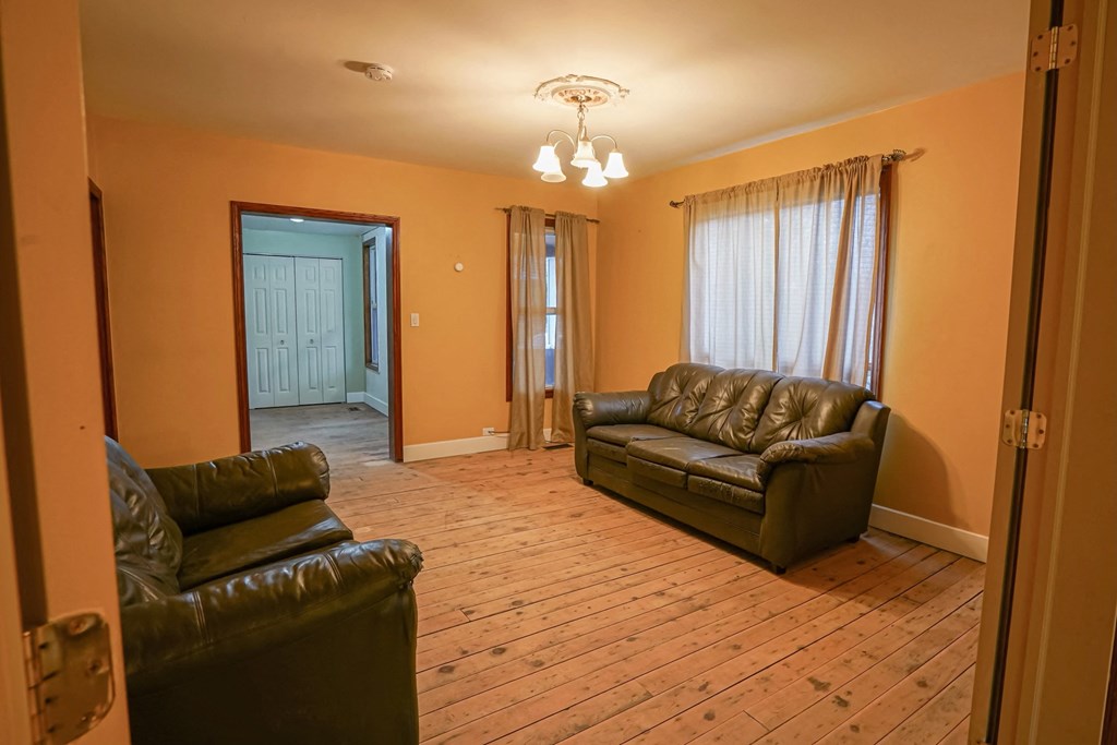 a living room with leather couches and a wooden floor