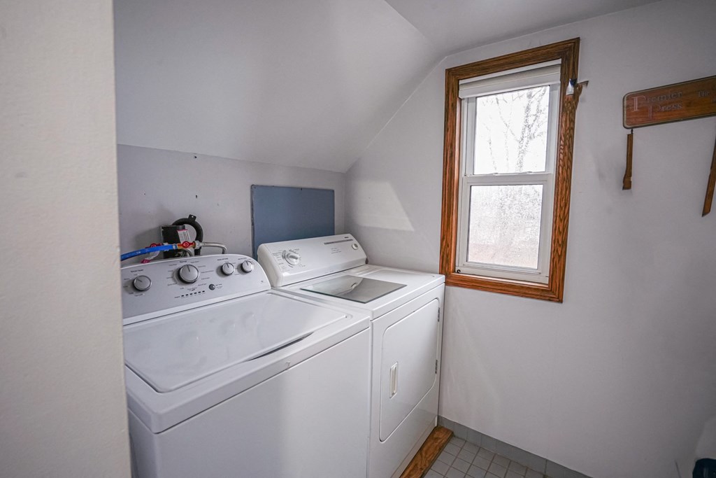 the laundry room has a washer and dryer and a window