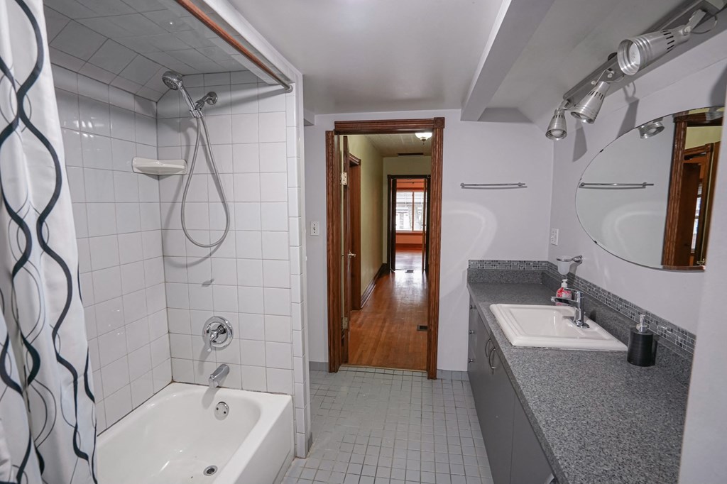 a bathroom with a tub and a sink and a mirror