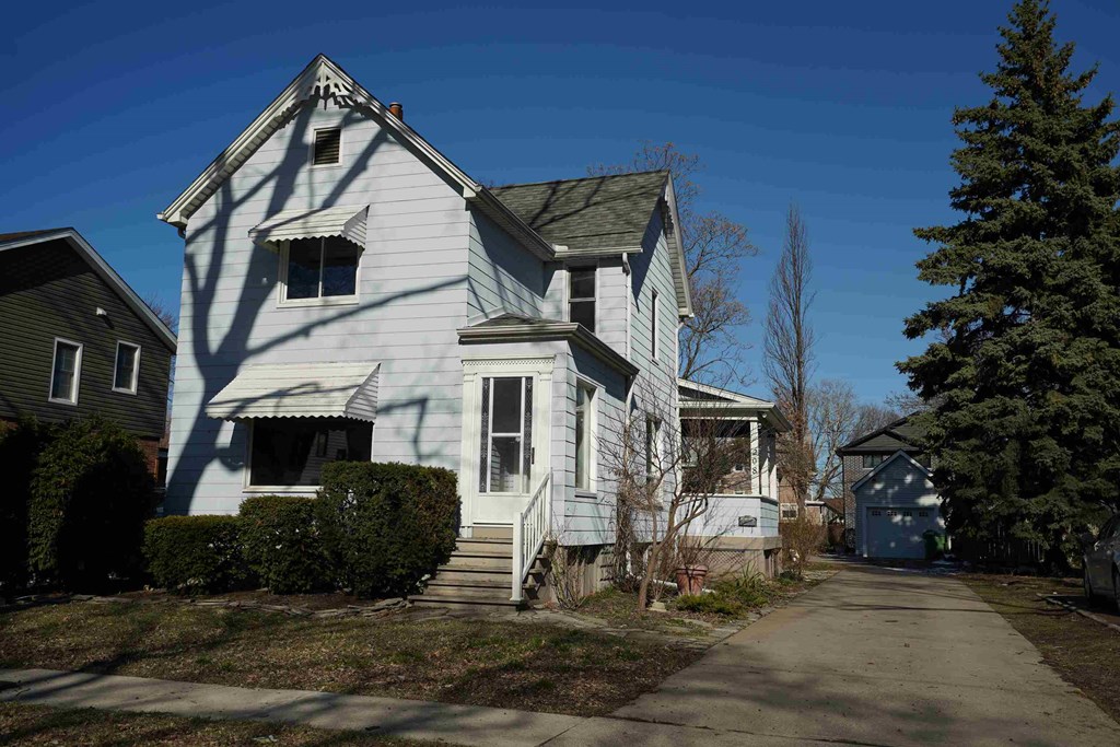 a white house with a sidewalk in front of it