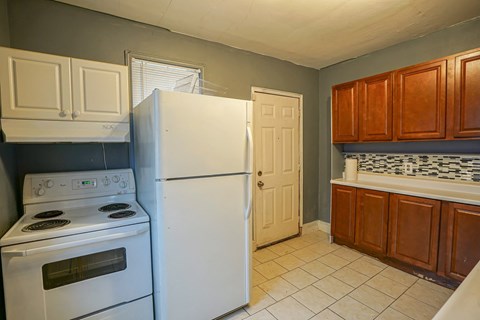 a kitchen with a refrigerator and a stove and a door