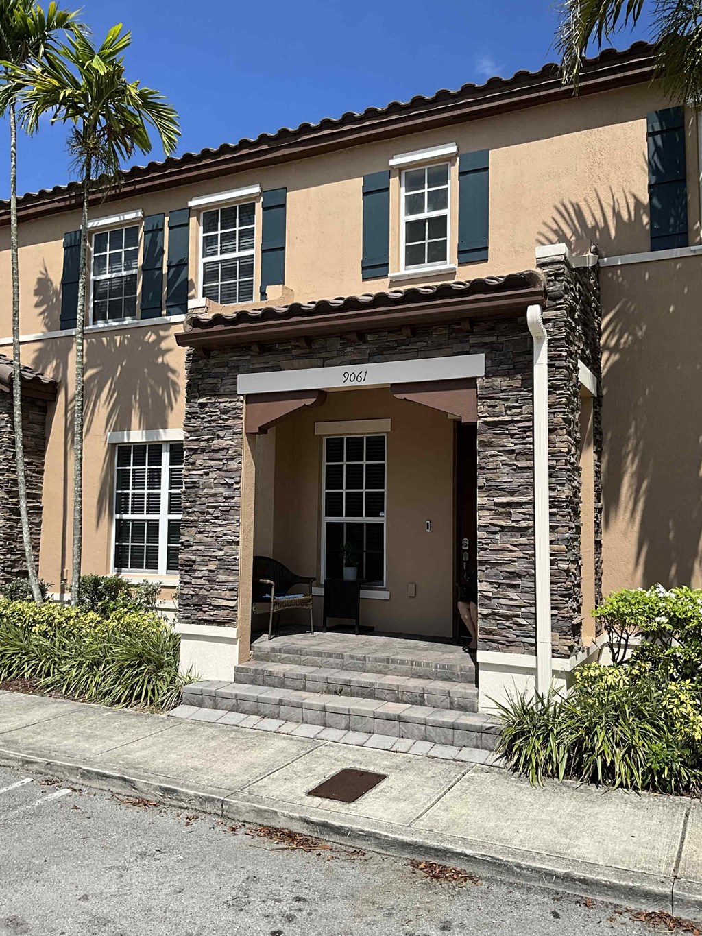 the front entrance of a building with steps and a sidewalk