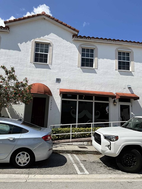 a white building with cars parked in front of it