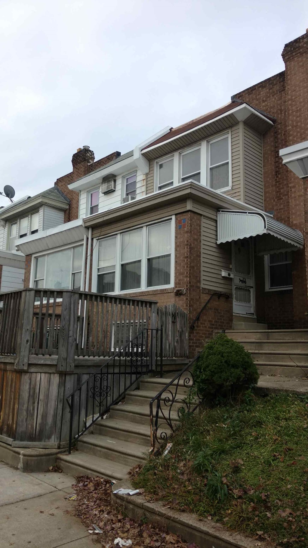 A brown house with a black iron fence.