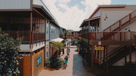 A street view of a building with a blue sign on the left.