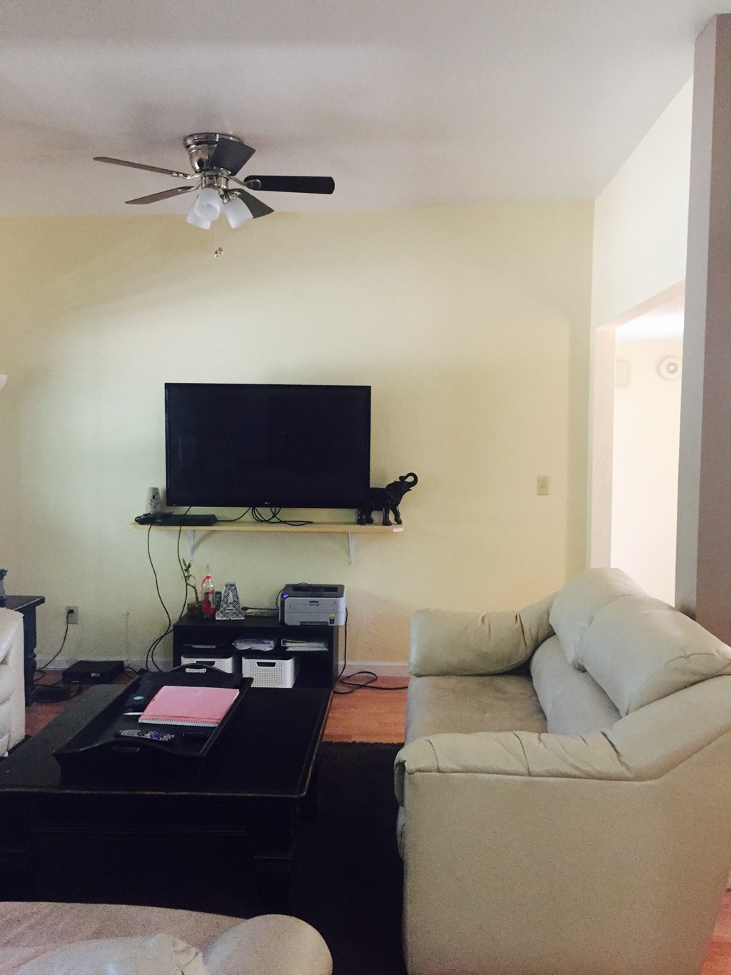 A living room with a television, a couch, and a coffee table.