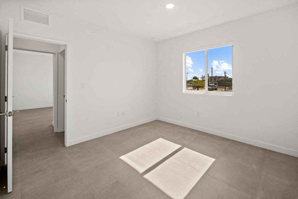 an empty living room with a window and a door