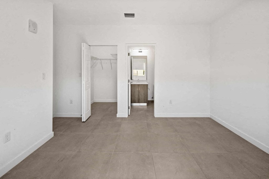 an empty living room with white walls and a cement floor