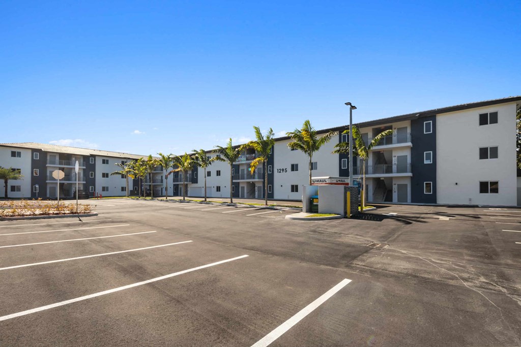 an empty parking lot in front of an apartment building