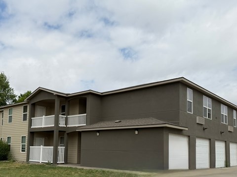 A two-story apartment building with a balcony on the second floor.