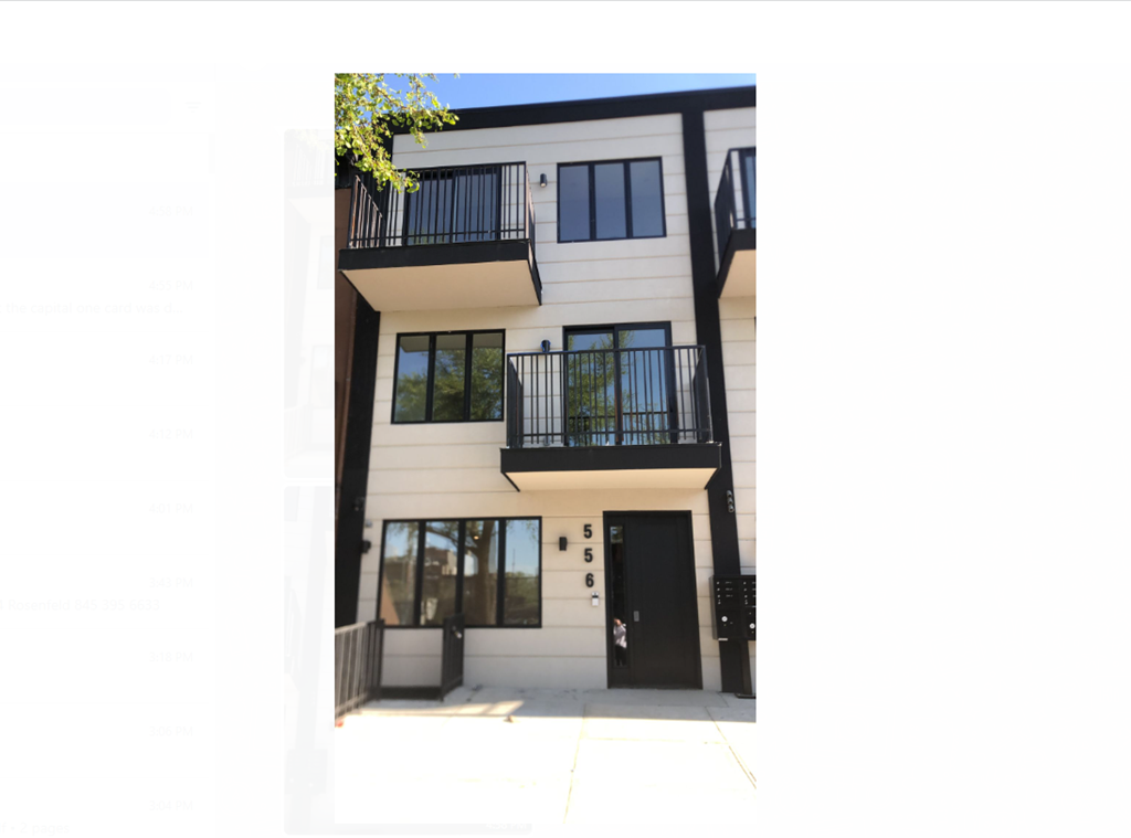 the front of a white building with balconies and a black door